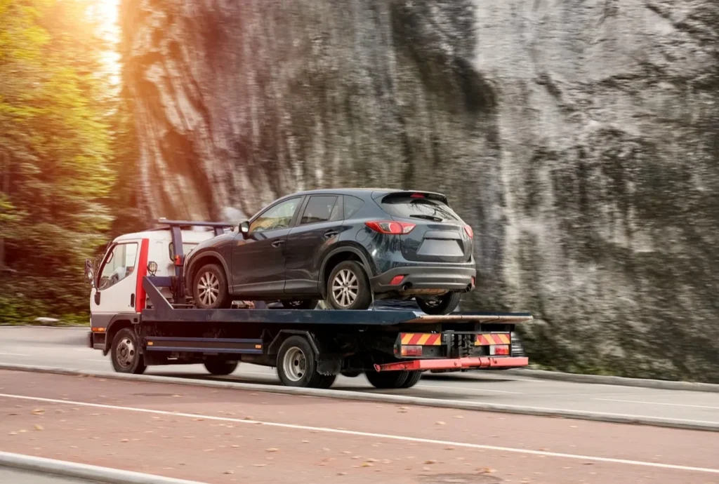 Selling a Junk Car in Houston Heights, Katy, Pasadena, and Beyond A tow truck transporting a disabled SUV on its flatbed
