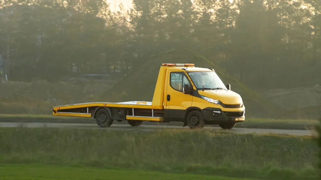 Older vehicles and a tow truck at a professional auto-recycling facility