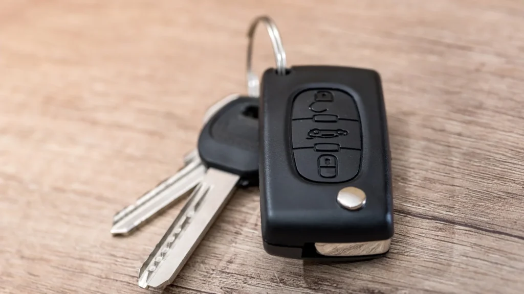 Car keys and remote on a wooden desk