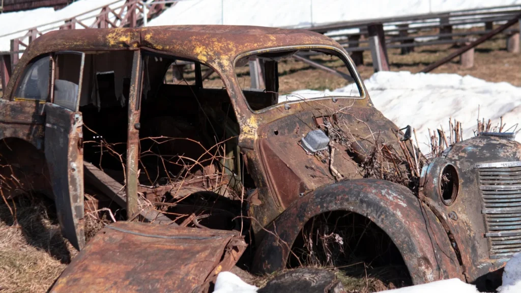 Heavily rusted older car in a snowy Nevada setting