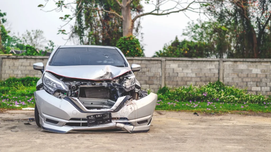 Car with front-end collision damage waiting for pickup