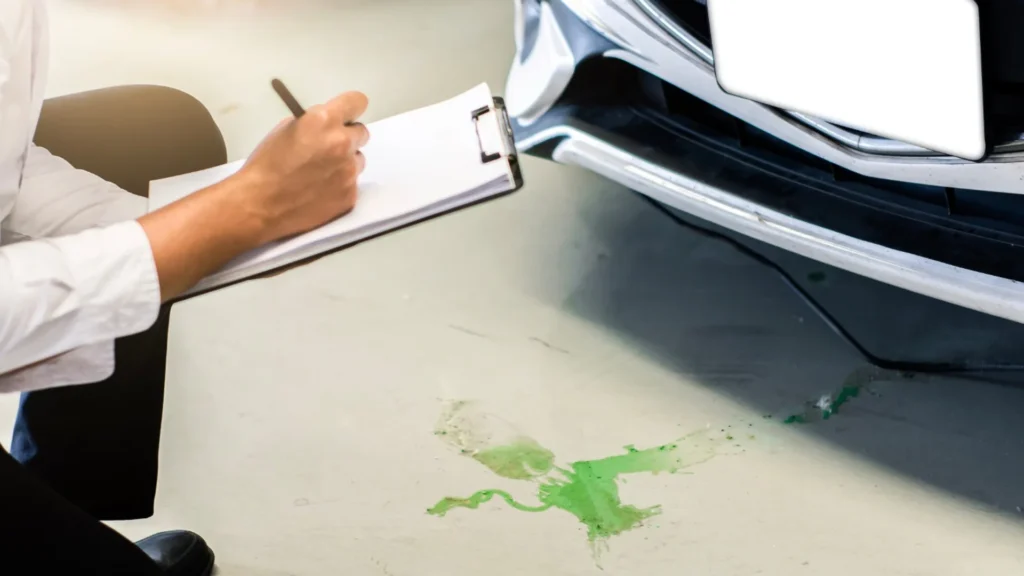 Older car with leaking fluid awaiting professional towing