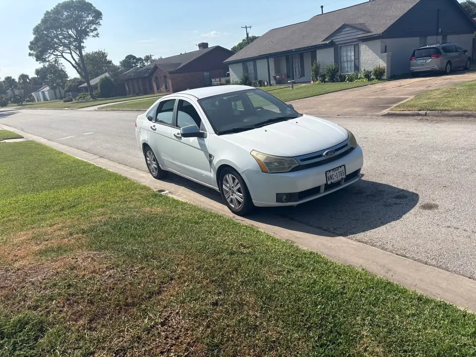 White 2009 Ford Focus SE with Texas license plates parked on a suburban street