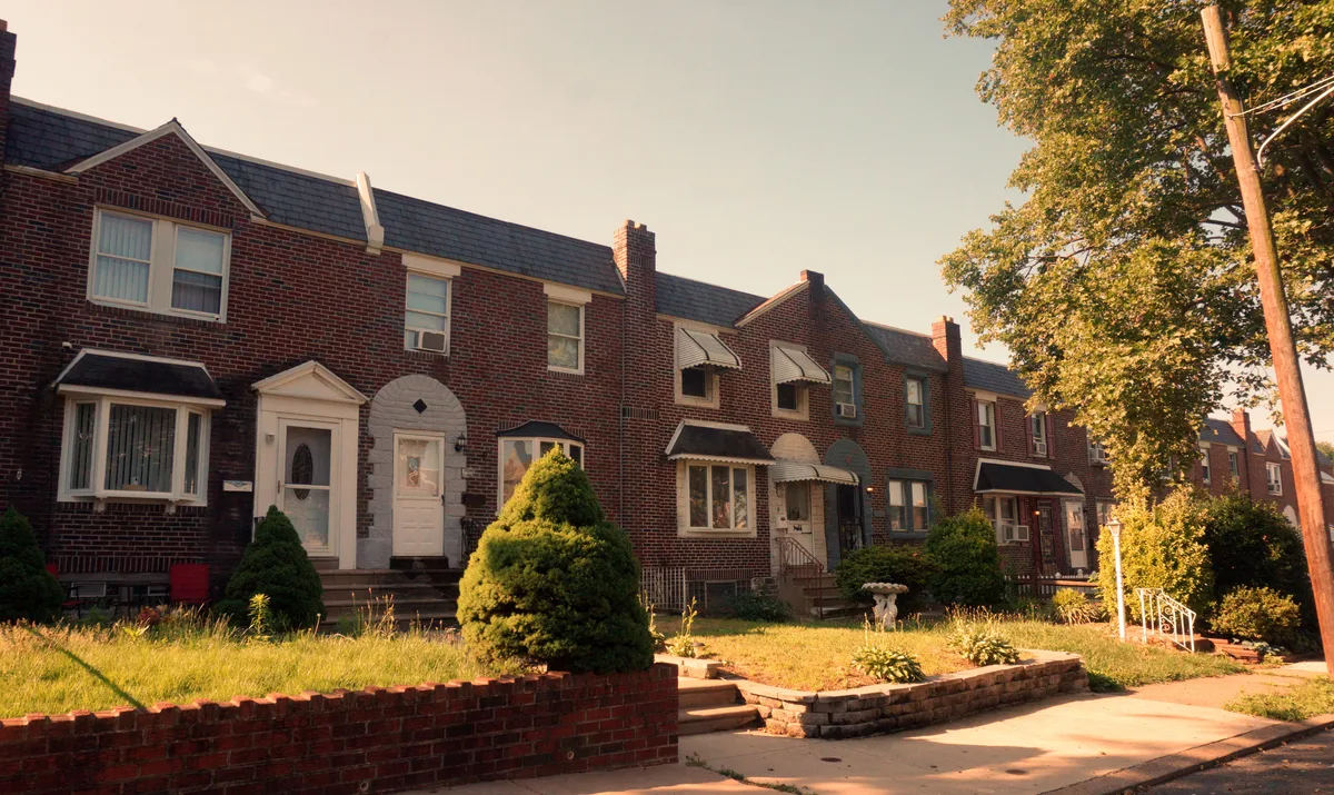 Brick row homes with narrow street parking typical of Philadelphia