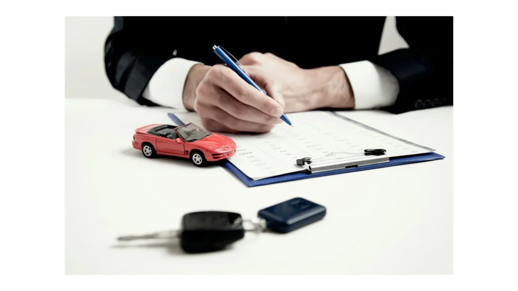 Person reviewing vehicle documents beside a model car