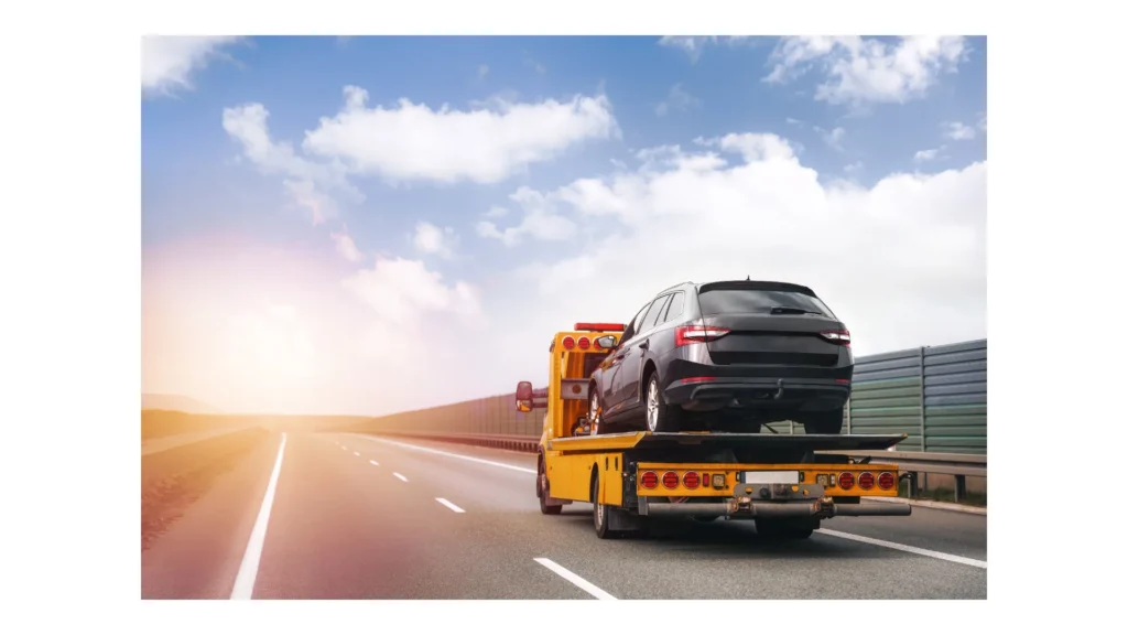 A tow truck on the public road. Tow truck with broken car on country road. Tow truck transporting car on the highway. Car service